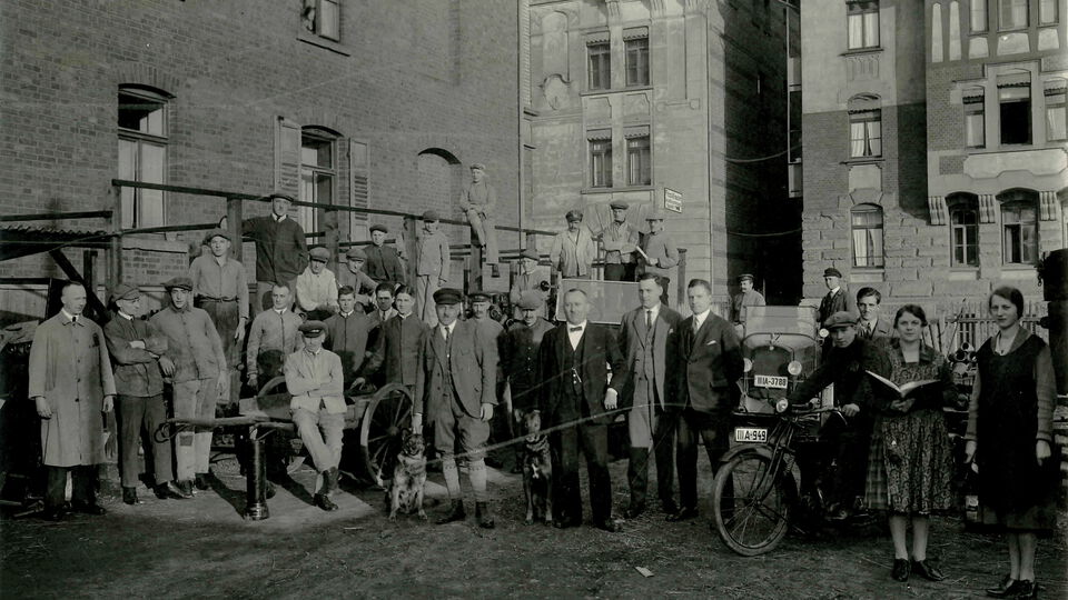 Eine Gruppe von Personen steht vor einem Gebäude und posiert für ein Foto.