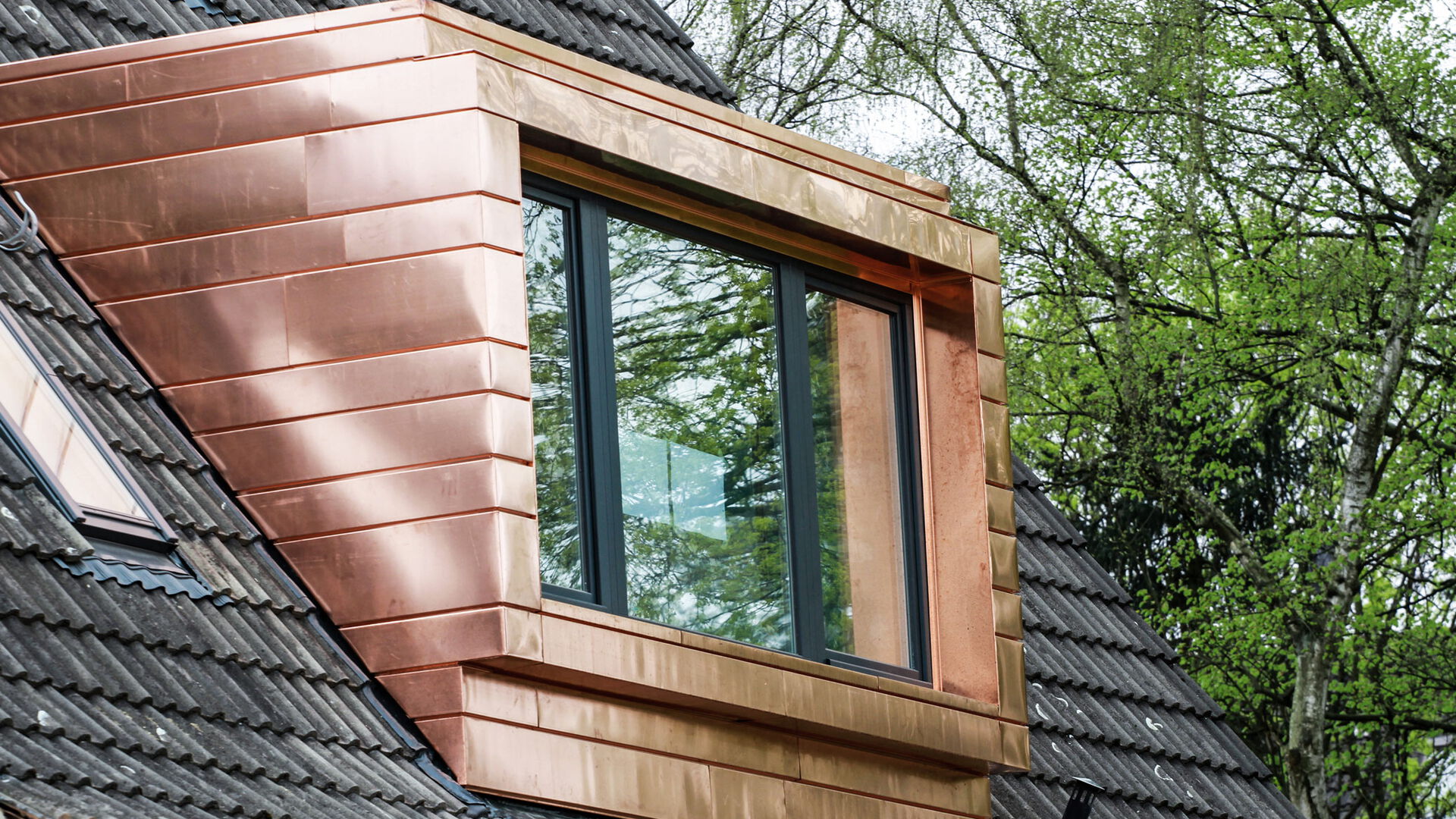 Ein Fenster auf dem Dach eines Hauses, das den Blick auf den Himmel freigibt.