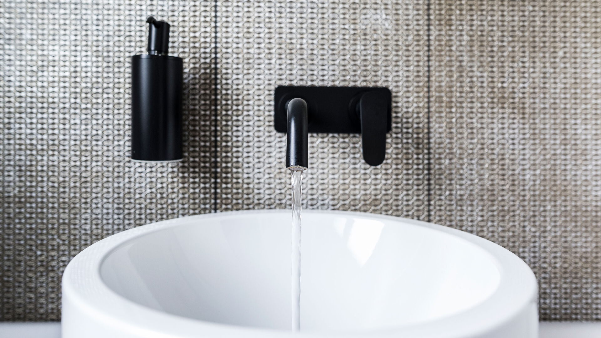 Moderne Waschbecken mit schwarzem Wasserhahn.