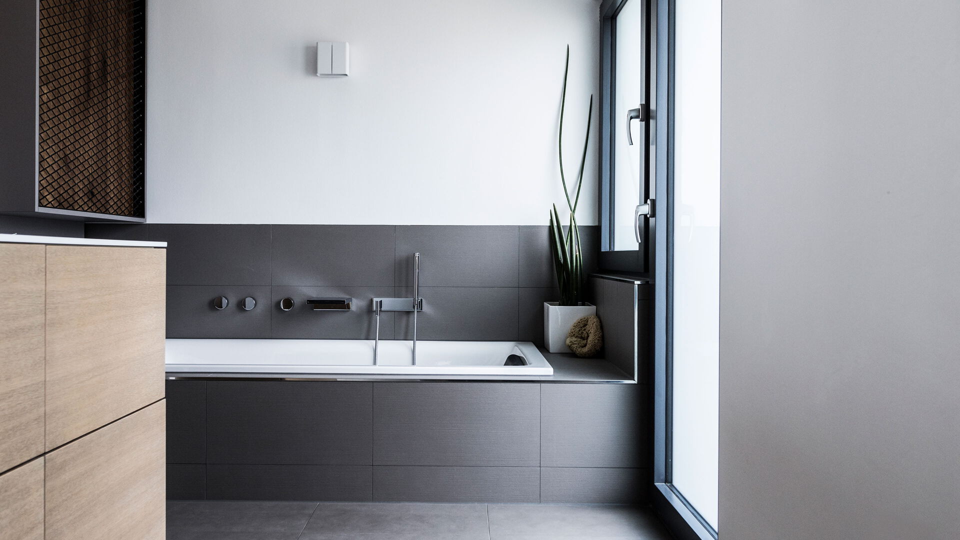 Modernes Badezimmer mit schwarzer Badewanne und Dekoration.